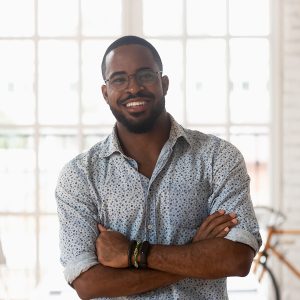 Smiling,Confident,African,American,Young,Businessman,Standing,With,Folded,Hands,